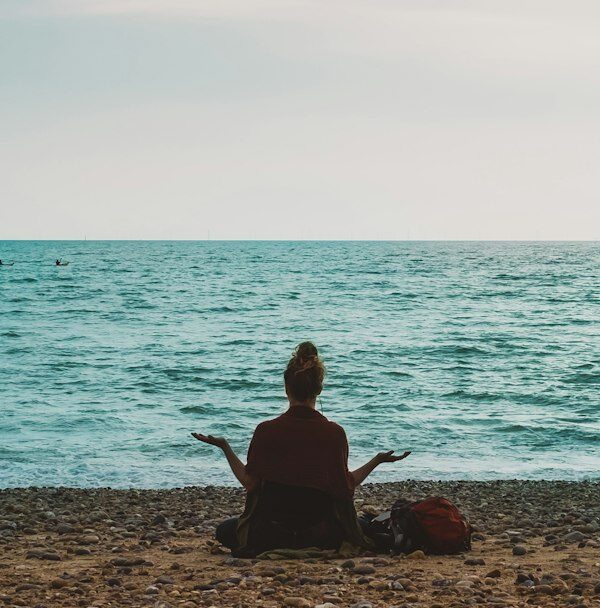 A person walking calmly by the sea as part of a steady wellness routine