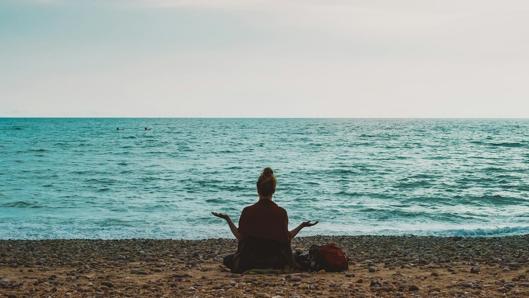 A person walking calmly by the sea as part of a steady wellness routine
