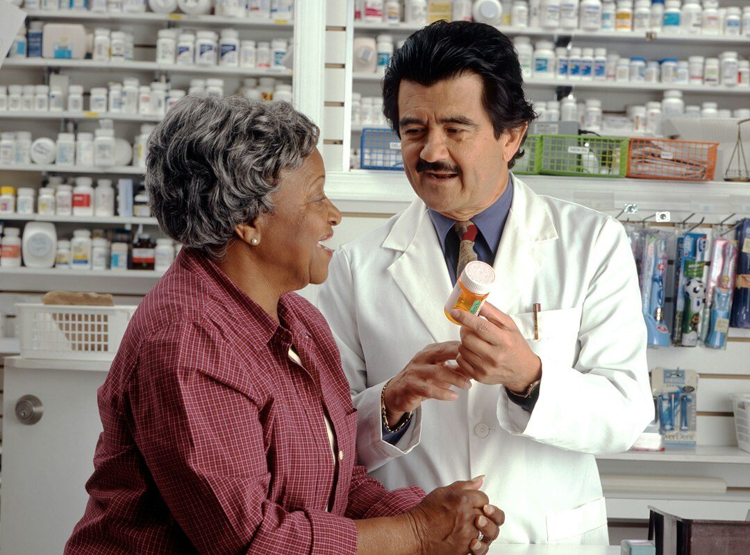 A healthcare professional reviewing prescription information with an adult patient