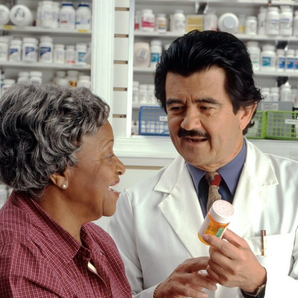 A healthcare professional reviewing prescription information with an adult patient