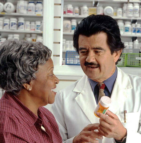 A healthcare professional reviewing prescription information with an adult patient