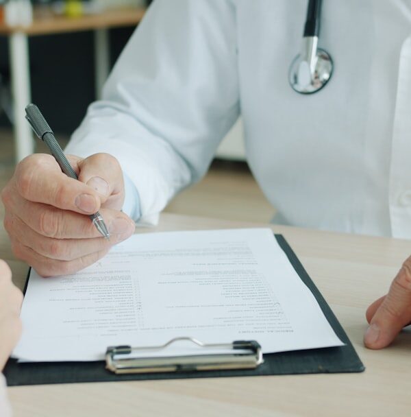 A clinician listening to an adult patient during a thoughtful psychiatric evaluation