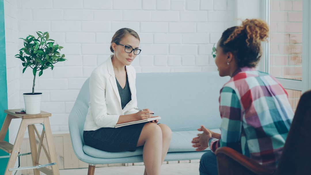 A mental health professional listening and taking notes during an evaluation